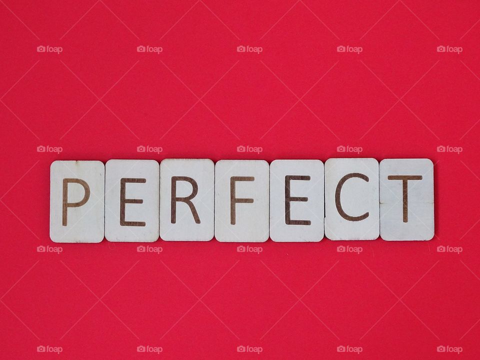 Perfect Spelled out with wooden letters on a red background