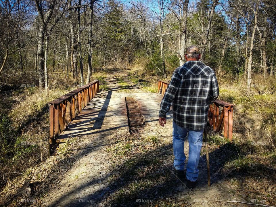 Man Walking By a Bridge