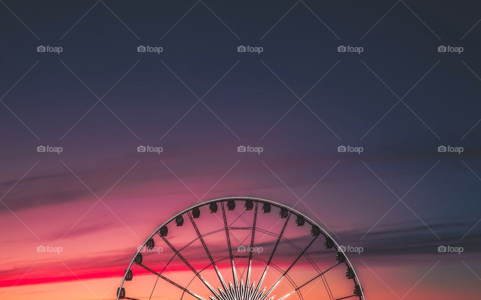 Ferris wheel against dramatic sky