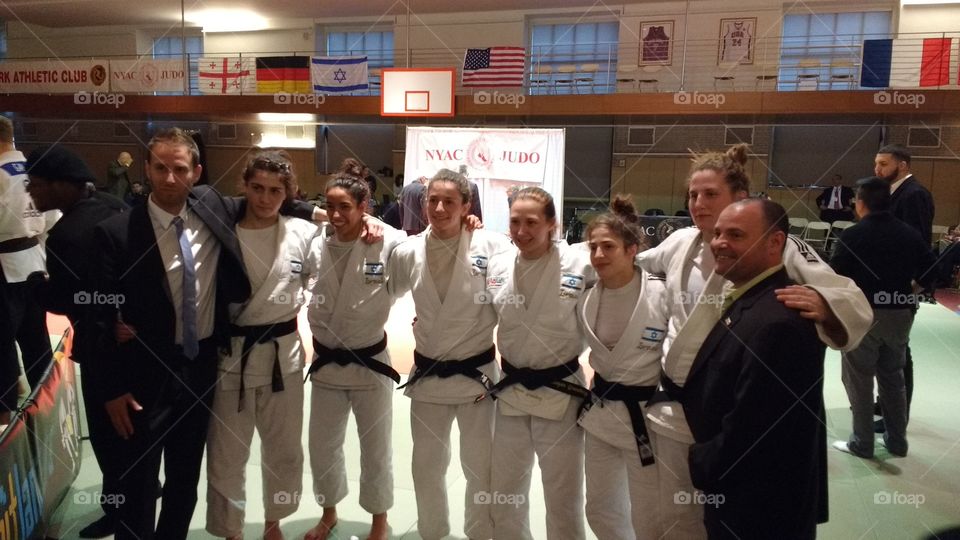 Women's team posing for Photo with Judo Coaches