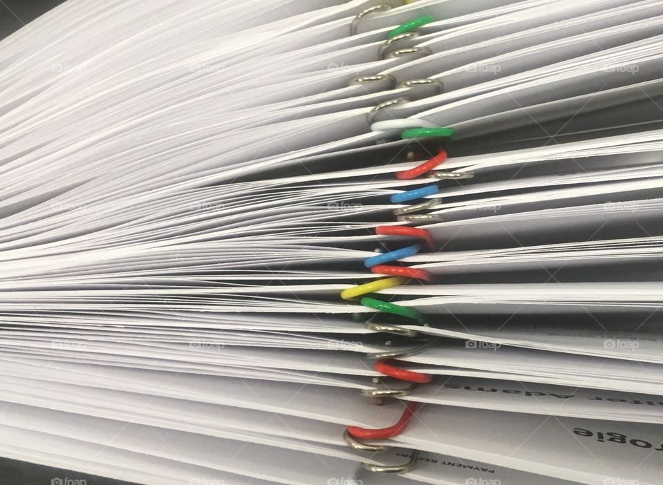 Paperwork batched by client and collated for filing. At office in Southwark, London.