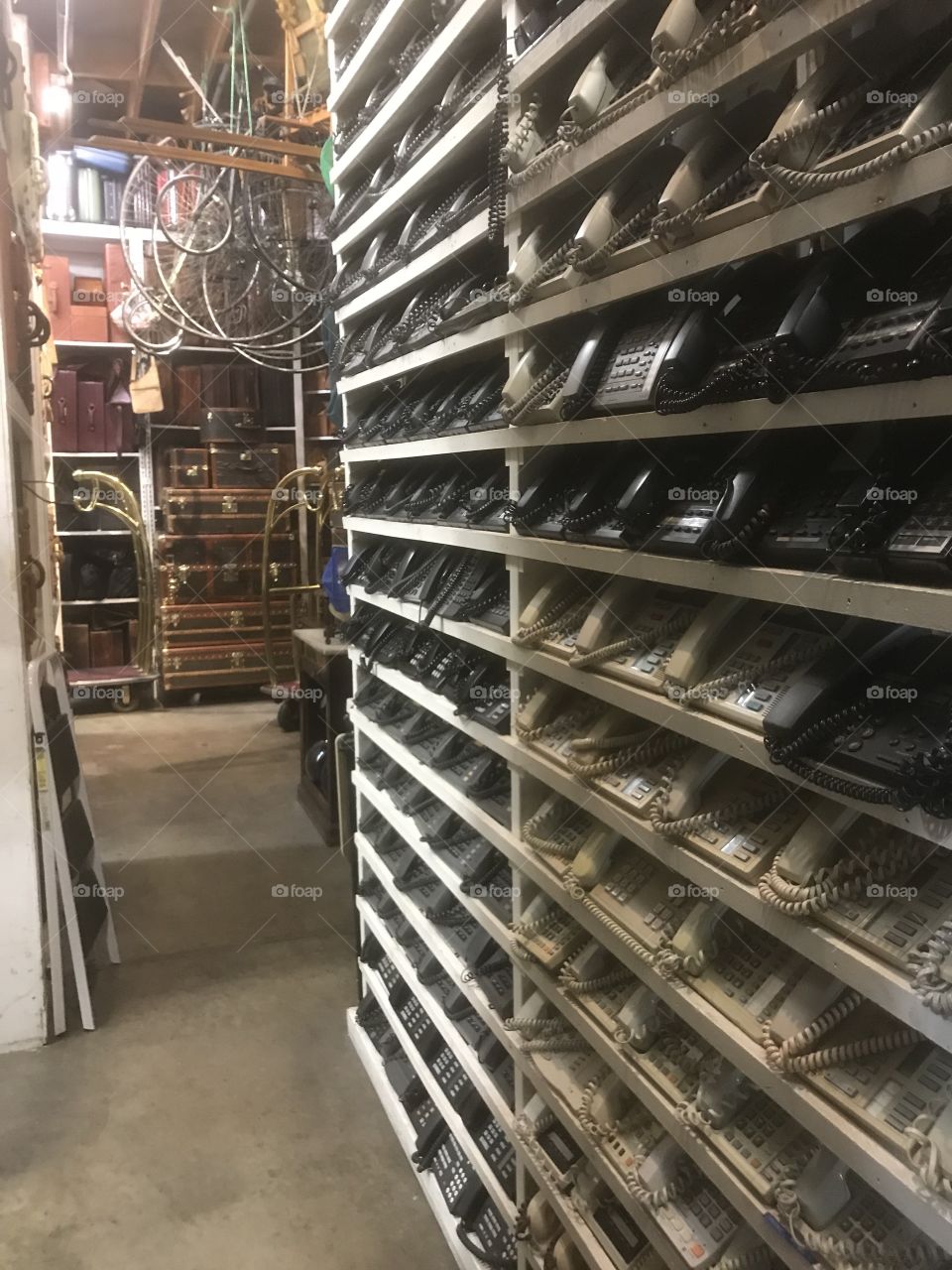 High shelves filled with many types of telephones displayed as a collection at a prop house