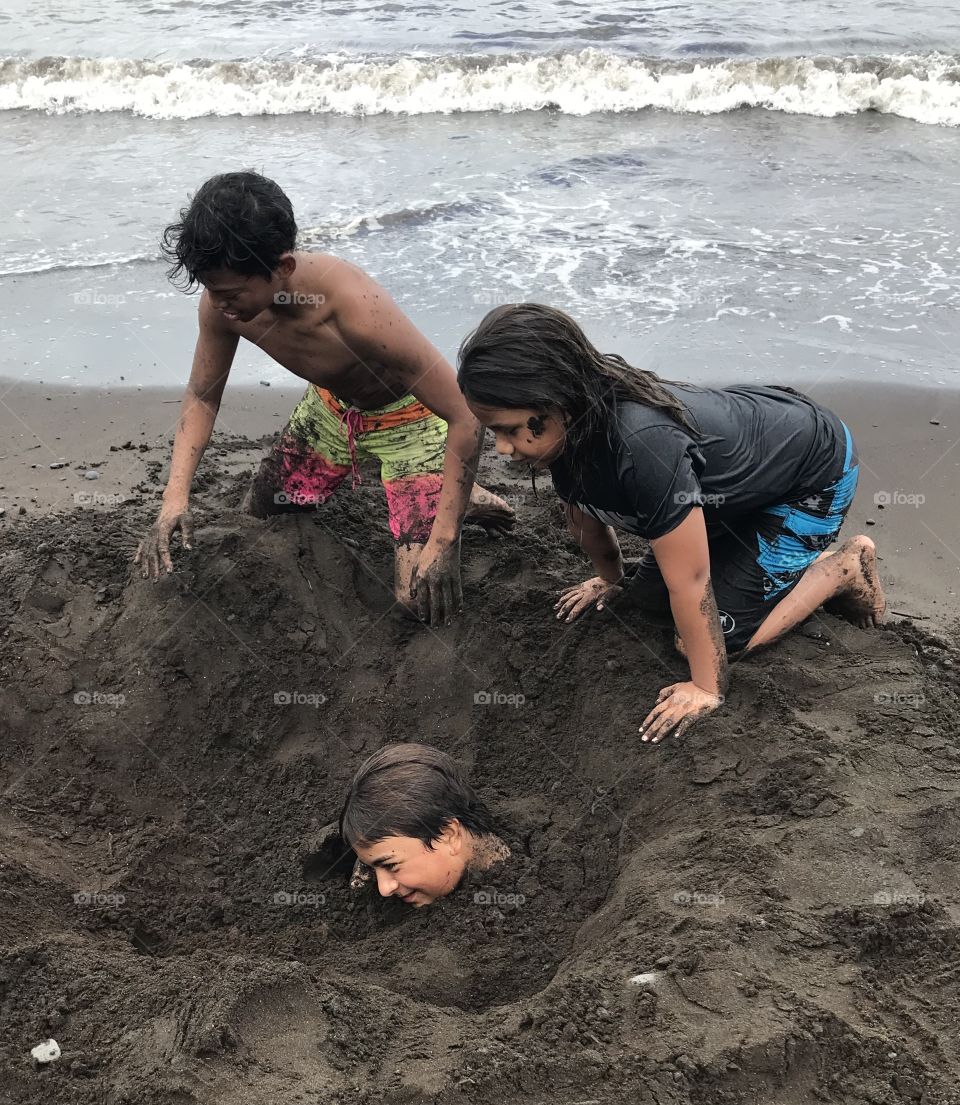 Burying a friend in the sand. 