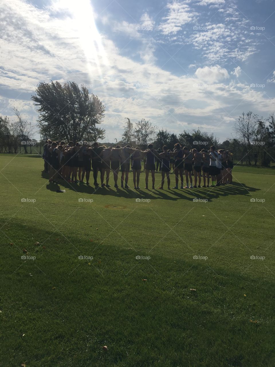 Praying before cross country meet. Sunshine beaming on them 
