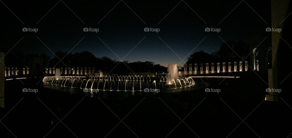 Washington DC Monument, dark sunset background. Water decor spouts with lighting behind them.  