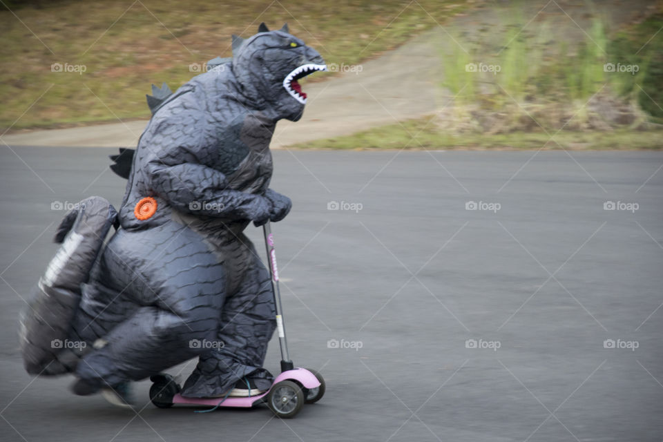 Dinosaur riding a scooter 