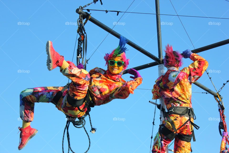 acrobat girl hanging in the air on a safety rope