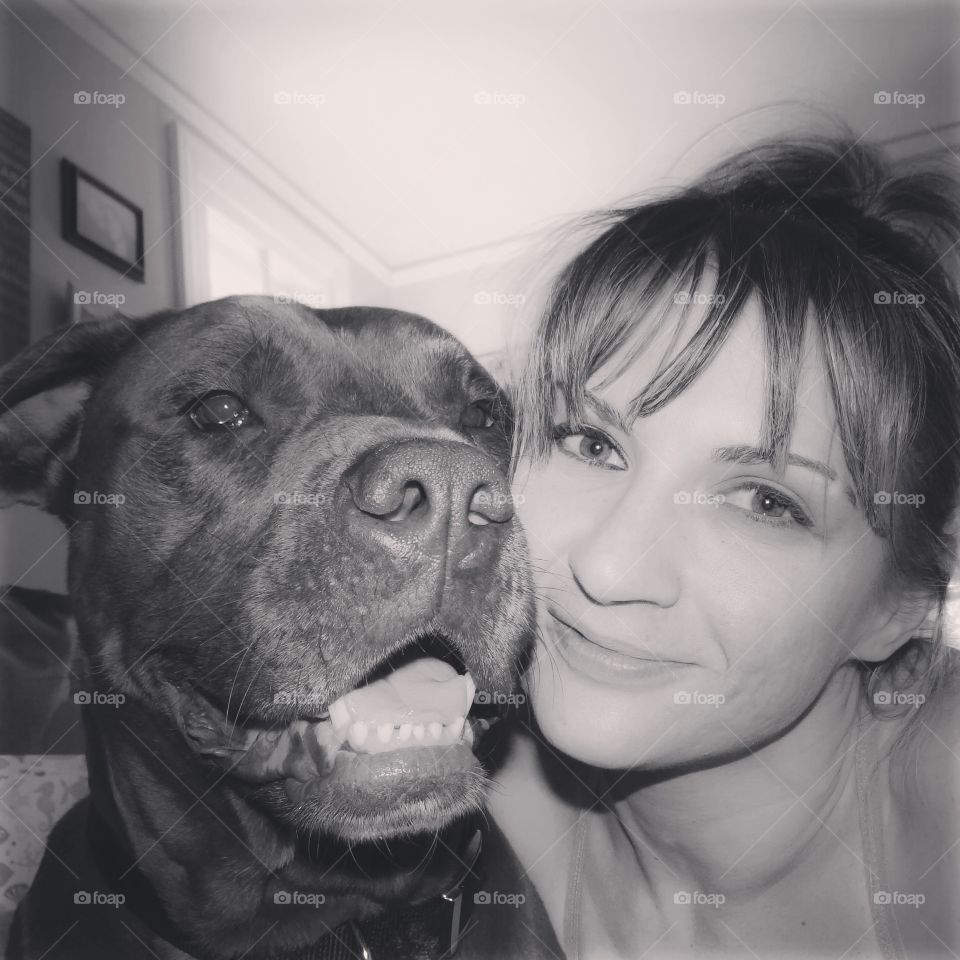 Girls best friend. Young woman smiling with a Pit Bull