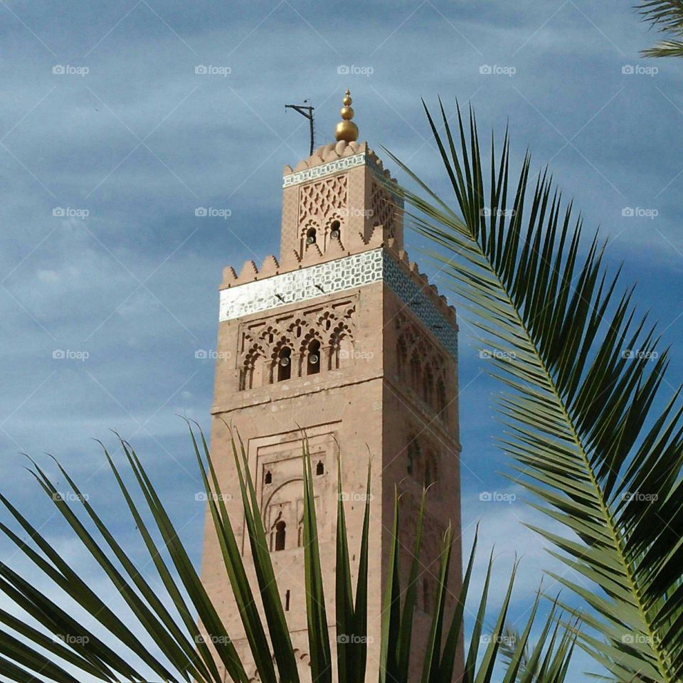 Beautiful minaret mosque and palm trees at marrakech city in Morocco.