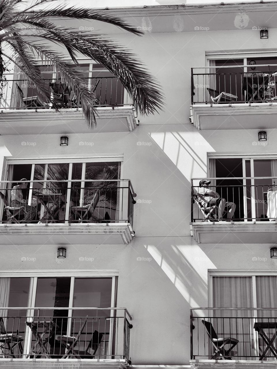 Sitges, Spain. Summer day, People resting in their balconies.