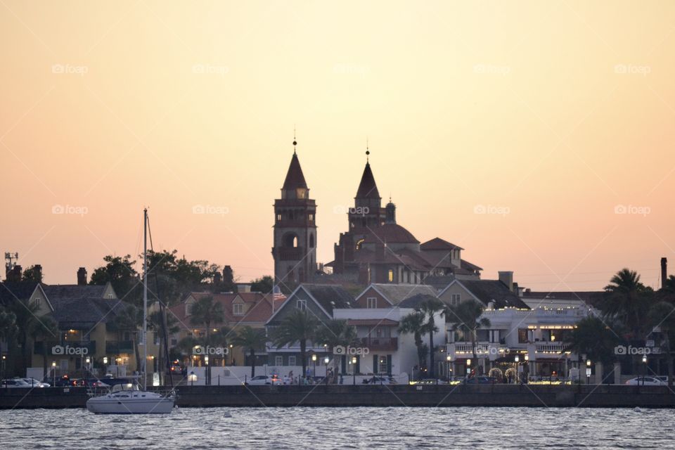 A view of a very old city from the water at sunset