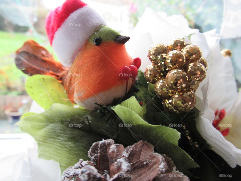 Christmas arrangement with robin wearing a Santa hat