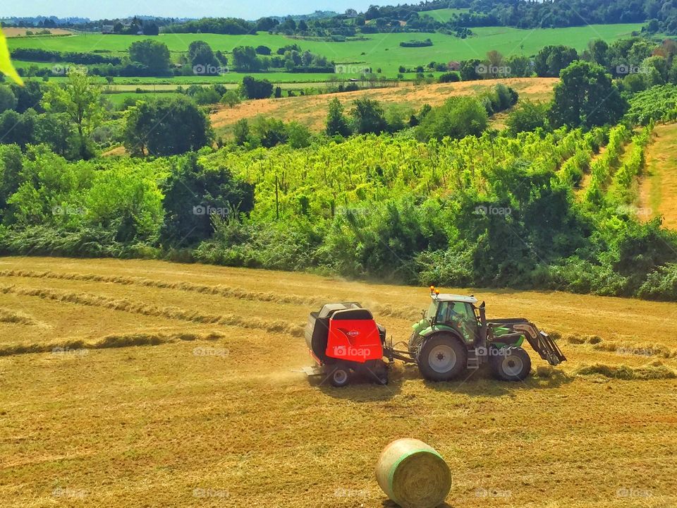 Tractor is moving. Tractor is moving in a big open field far from the city