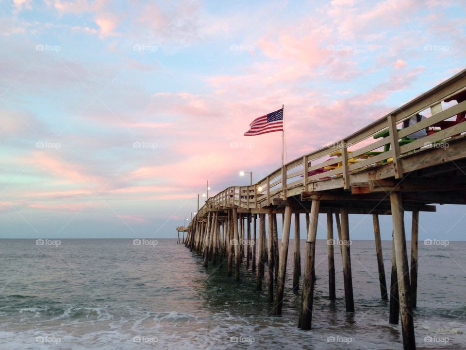 American flag blowing on a pier