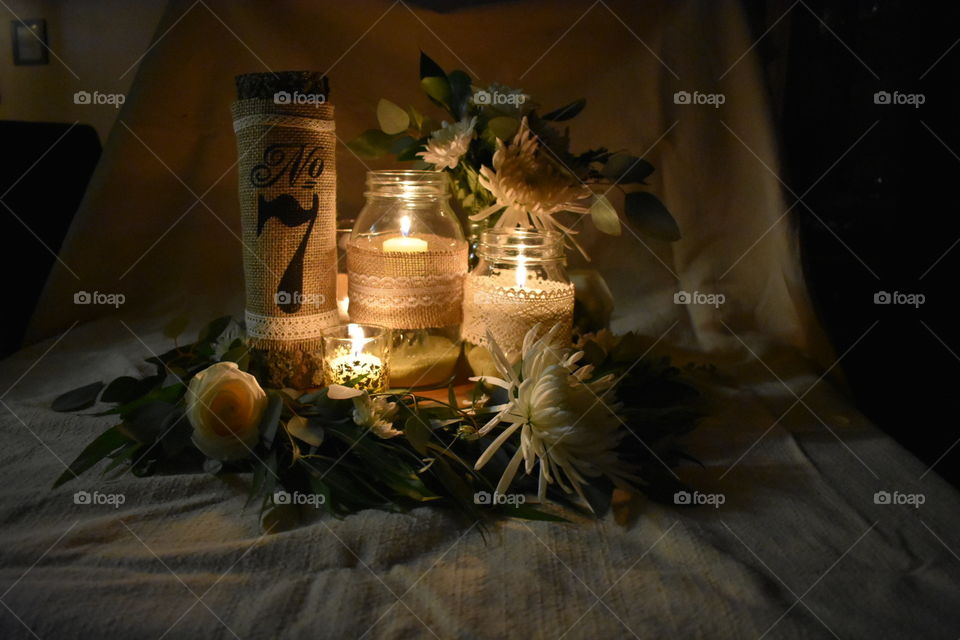 A frontal view of a delightful, romantic wedding centre piece. A rustic flair with a touch of whimsy thanks to the willow, eucalyptus, burlap, lace and natural wood. 