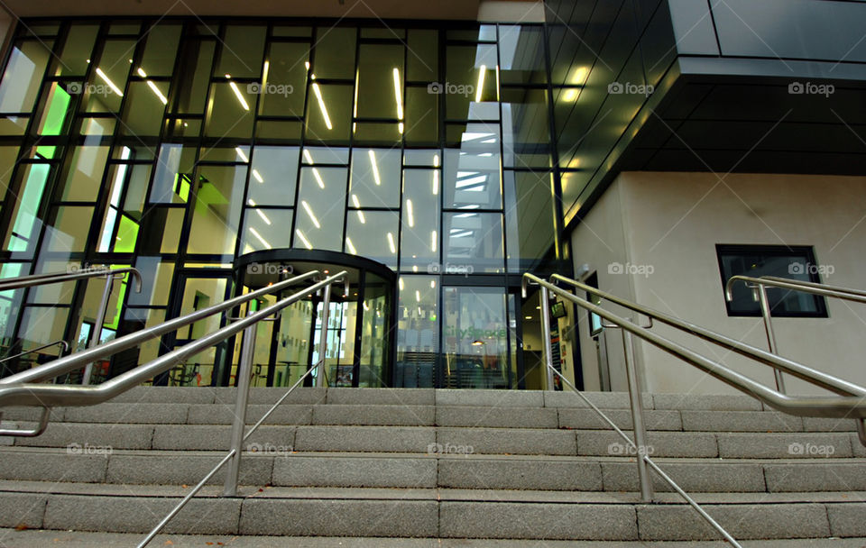 STEPS AND RAILINGS FRAME AND LEAD INTO A MODERN BUILDING WITH COLOURED
