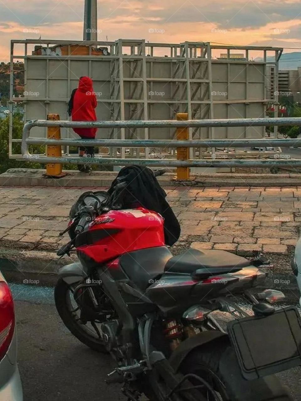 Dressed in red, riding a red motorcycle, he pulls aside to think, maybe to rest, or maybe just to look