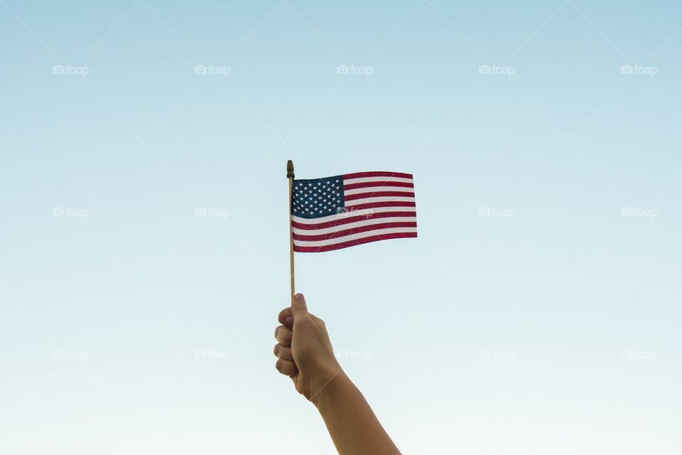 Hand holding small USA flag