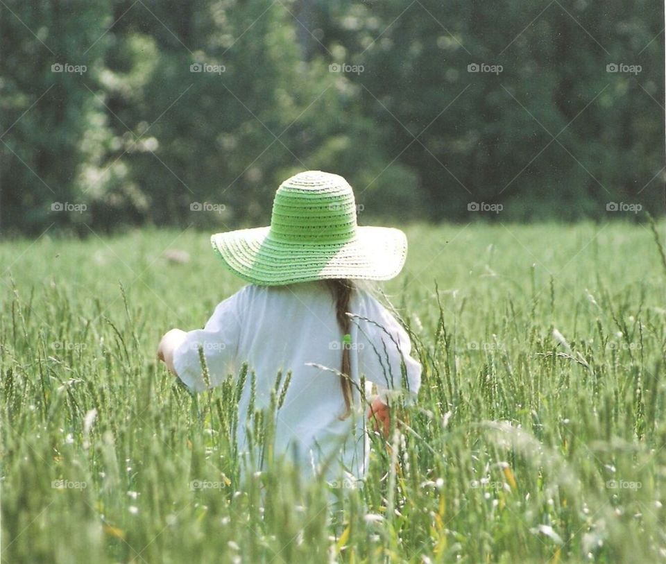 Girl walking through tall grass