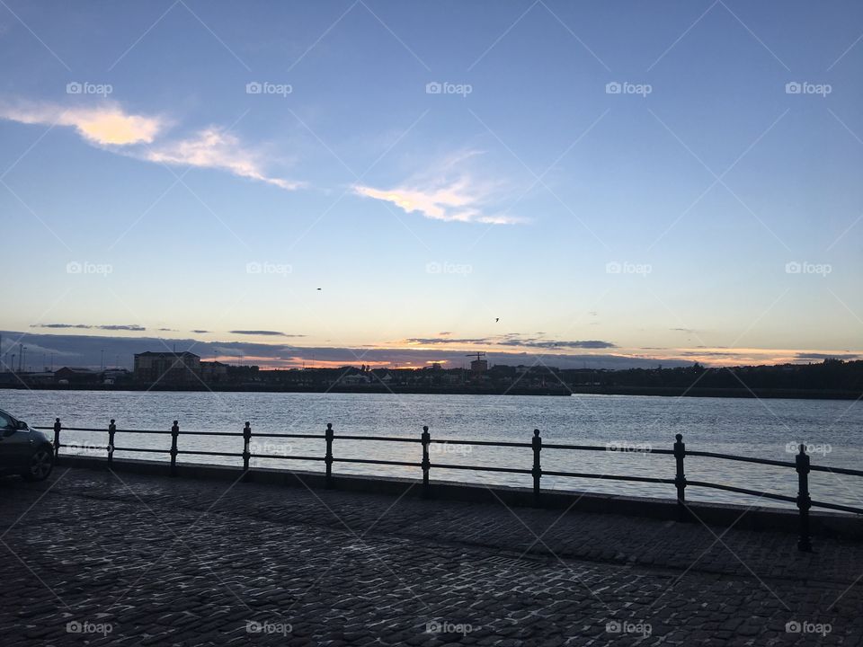 The river Tyne viewed from the banks of South Shields, the sun is about to start to set behind the city for the night, while I enjoy the gentle river breeze and the clear sky.