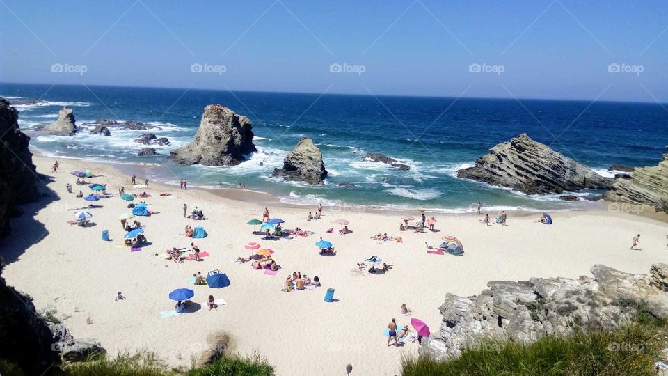 People enjoying a wonderful sunny day in one of the many beautiful beaches in Alentejo, Portugal.