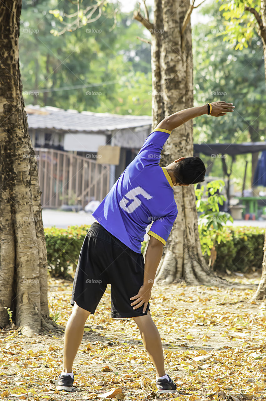 Asean man is warmed up before exercise in the park.