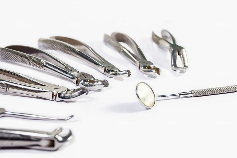Dental instruments arranged on white