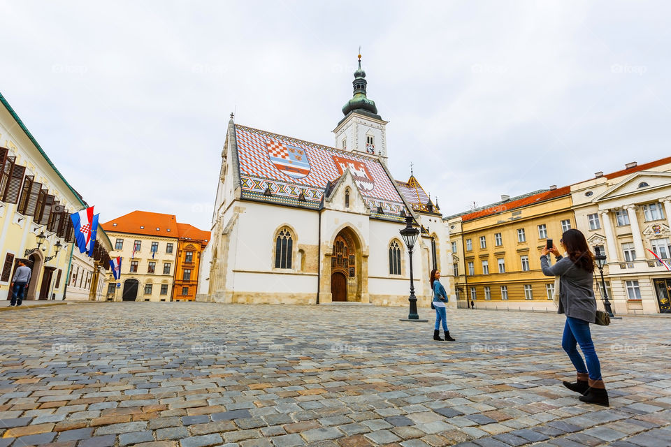 Woman photographing in front of church