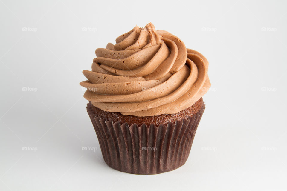 Chocolate Cupcake. A chocolate cupcake in a brown case on a white background.