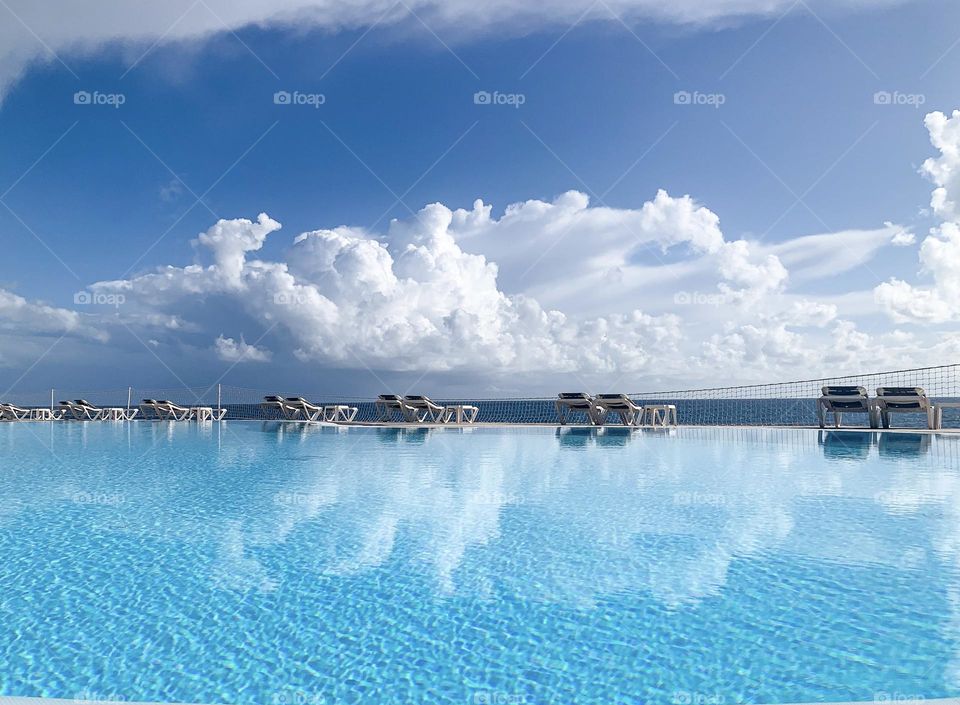 Blue sky and water surface with cloud’s reflection 