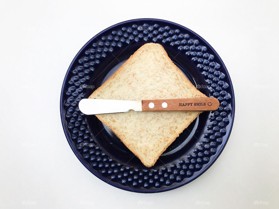 Sliced bread on a blue plate with butter knife