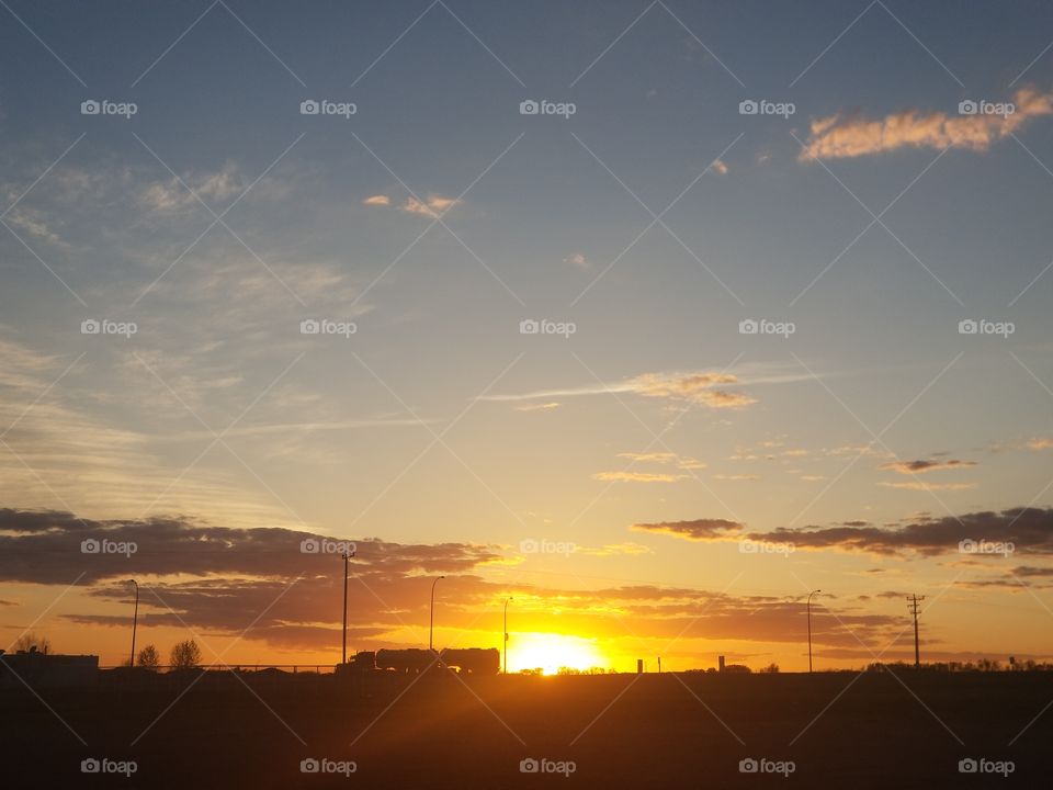 sunset near a highway way in a small town. life rolls on.