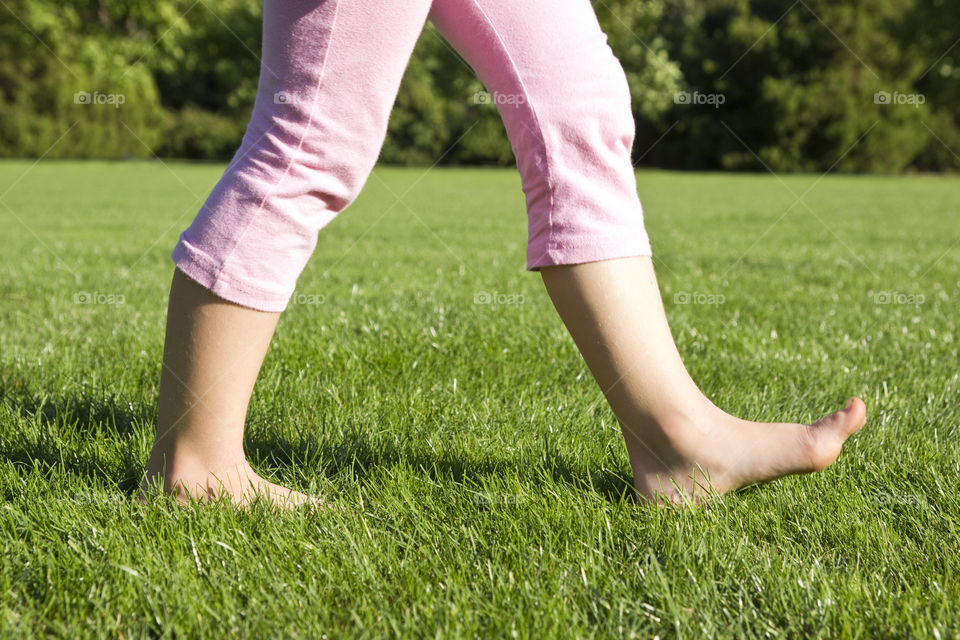 child walking barefoot on a grass