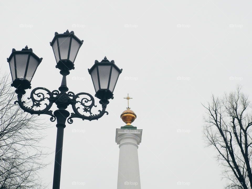 Street lamp and a monument against the sky