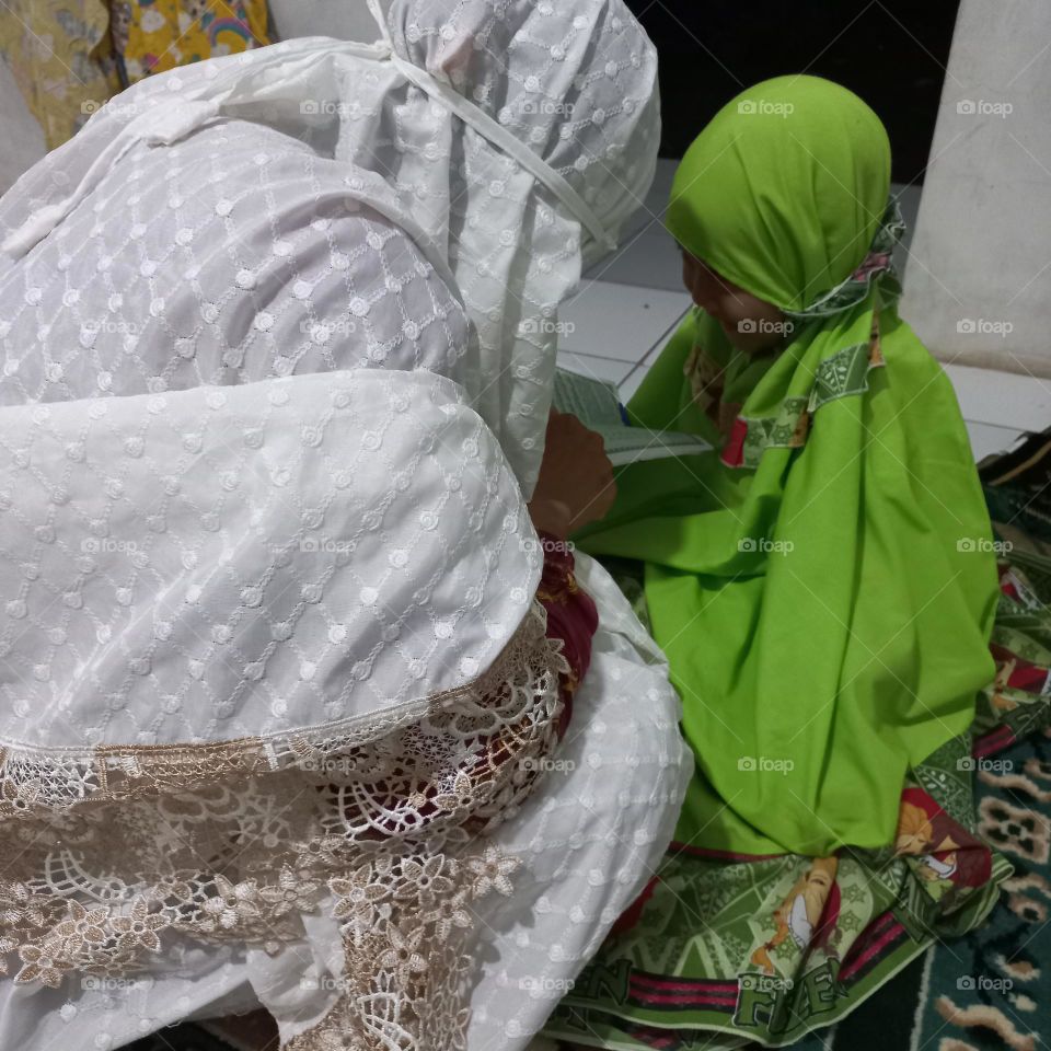 Little girl learning to read on the morning of ramadon
