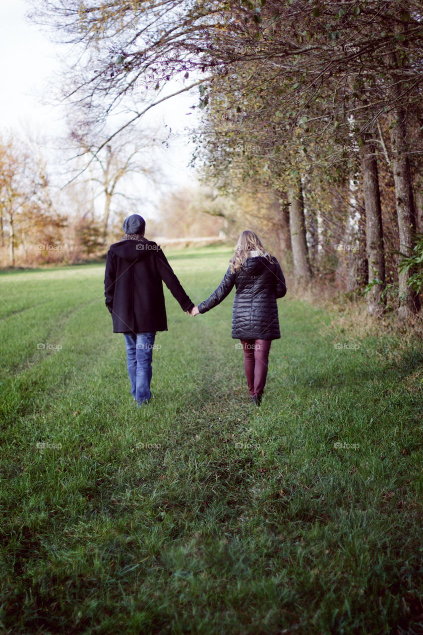 a Lösung pair with hold hands go for a walk and a Shooting in a park 