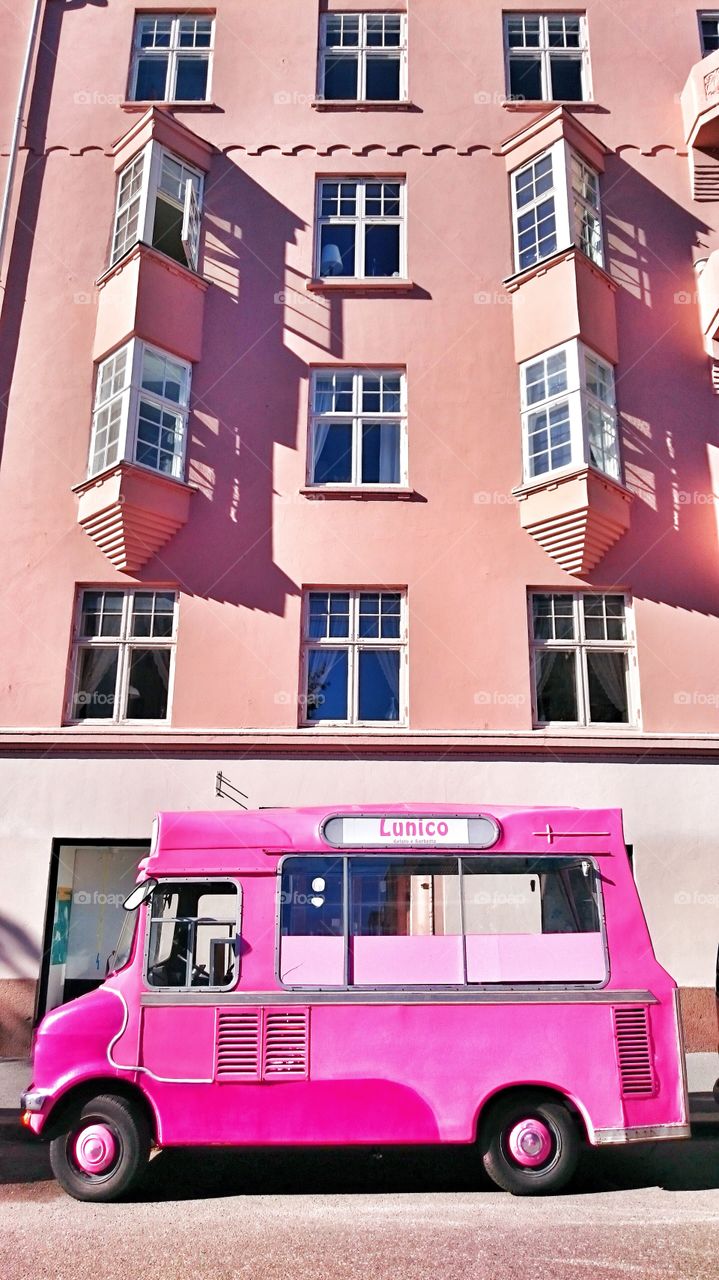 Pink ice cream truck near building