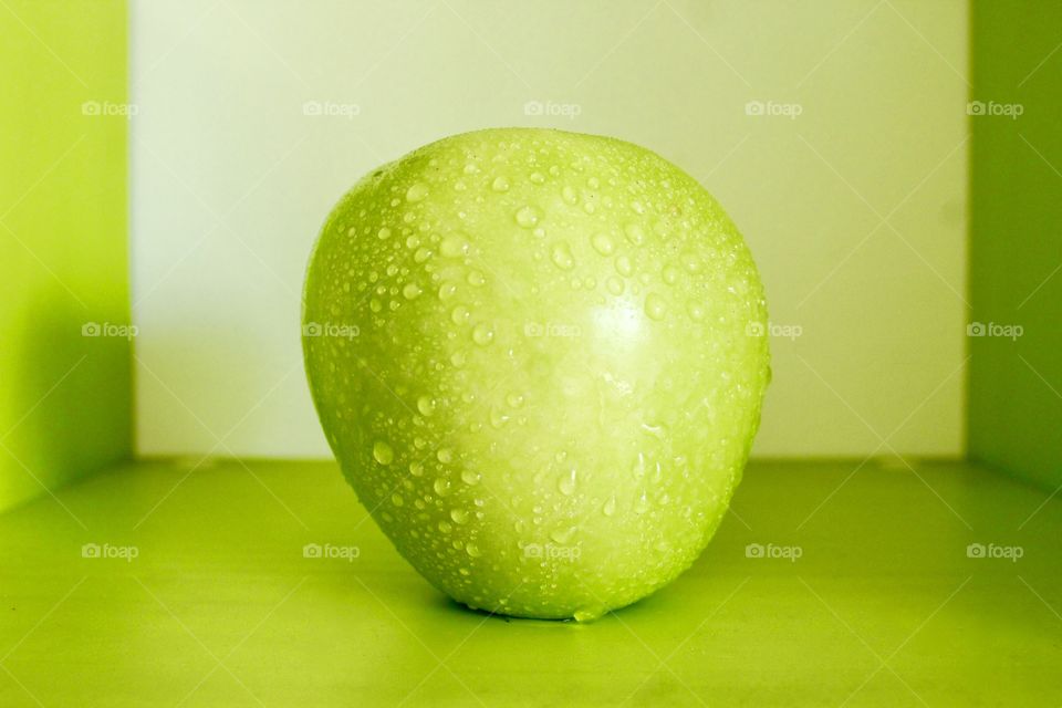 Green apple on green background