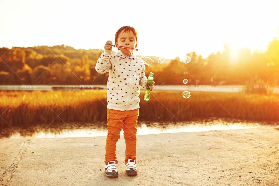 Bubbles story . Little boy playing with soap bubbles 