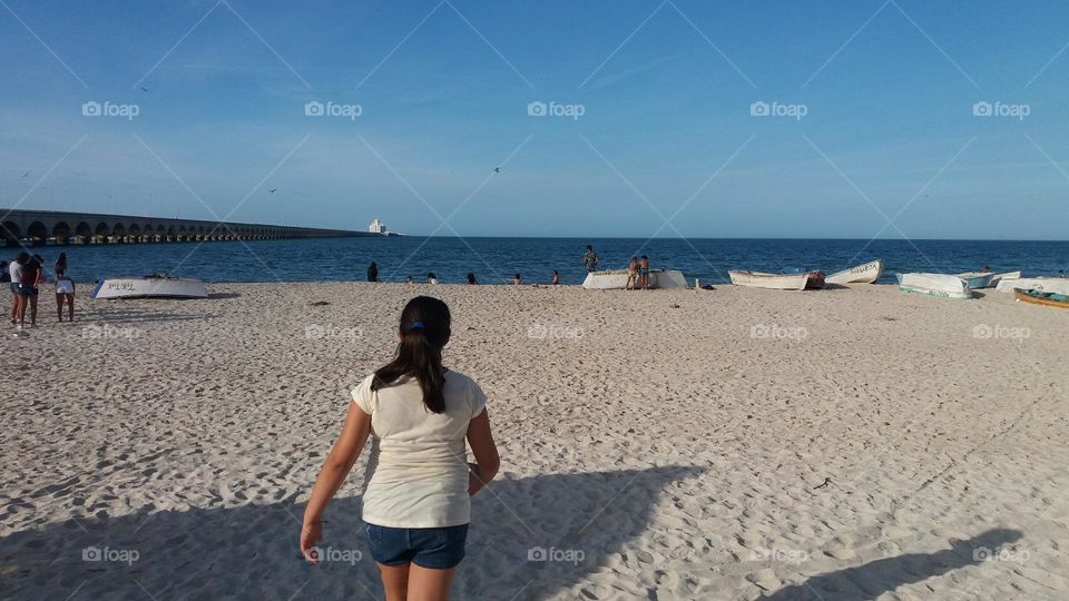 camina por la playa hacia el mar la niña