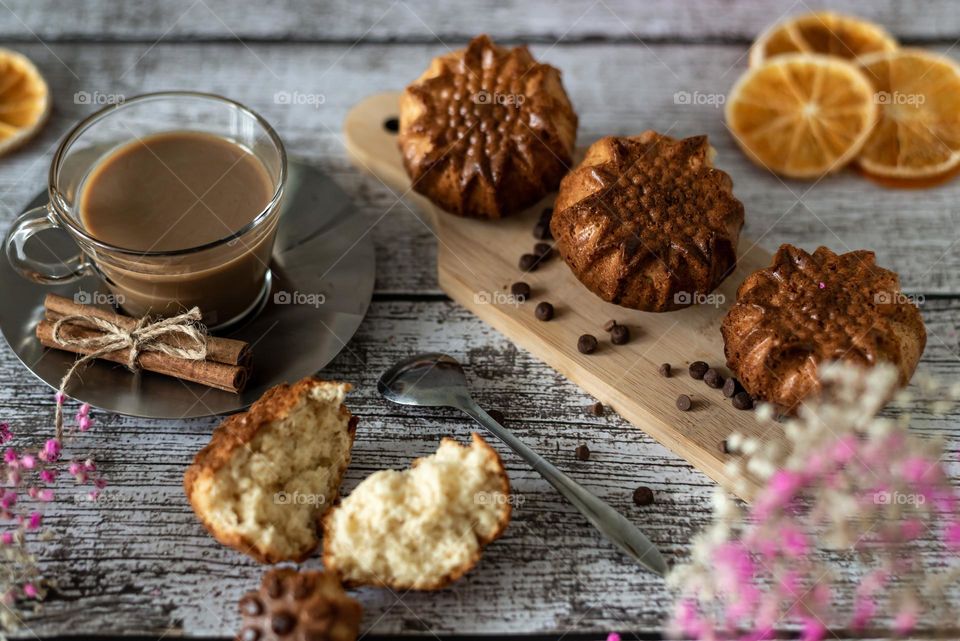 Homemade muffins muffins, homemade product, delicious breakfast with flowers and coffee on a wooden background