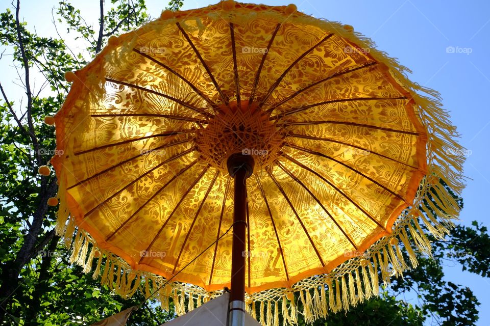 Yellow Asian cloth umbrella with patterns and tassels