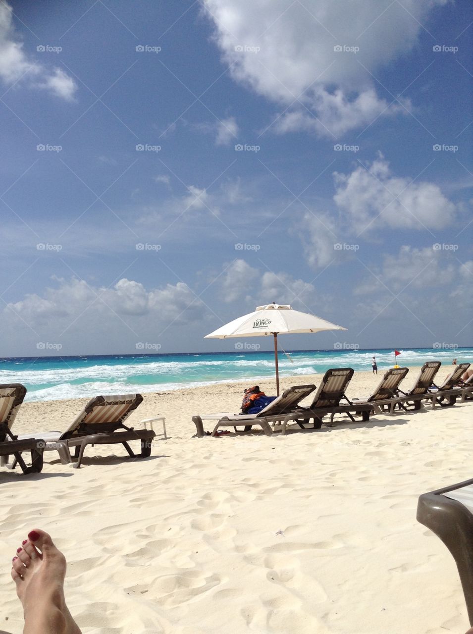
view of the beach with white sand and blue sea, beach umbrellas and sun loungers. Mexico, Cancun, the Caribbean Sea.