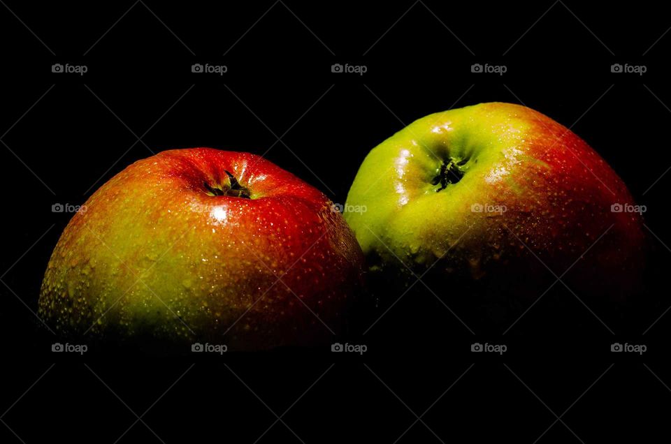 two apples on black background