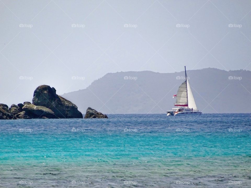 Let's go sailing. Boat in the distance off Hawksnest Beach in Caneel Bay on St. John USVI.