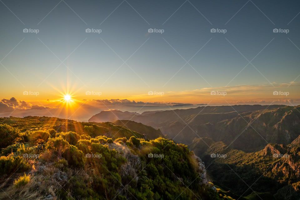 Sunrise in the summer in madeira on a hill facinh the hills and sea