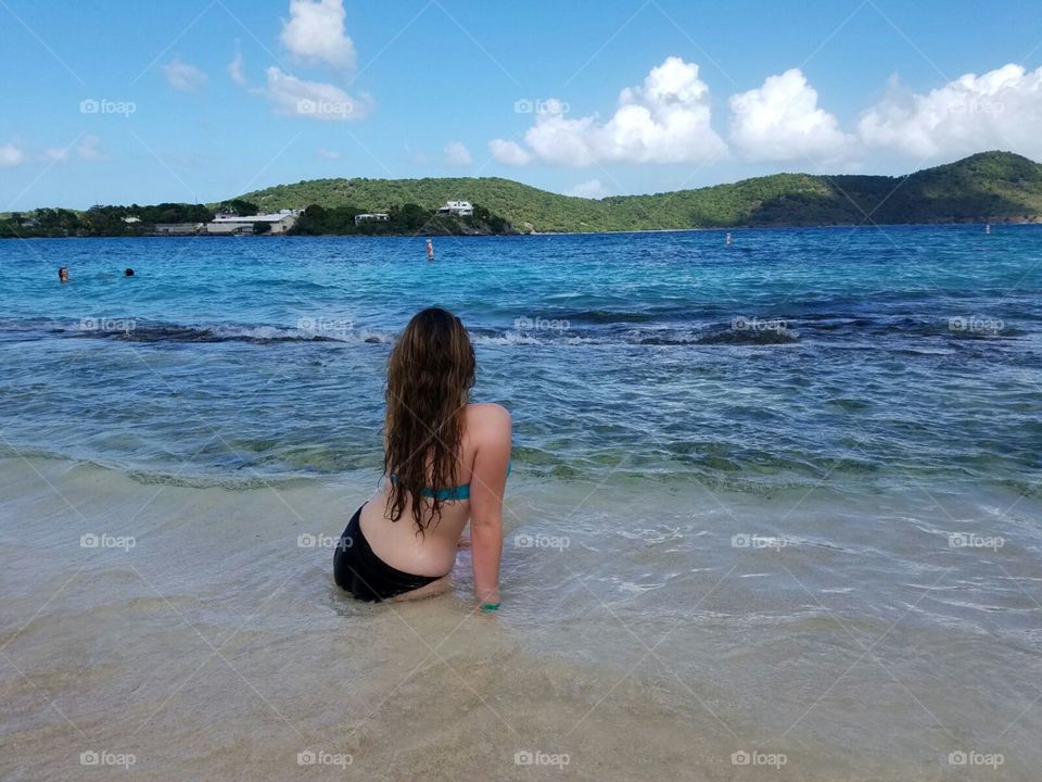 Girl on beach in Bahamas, overlooking another island