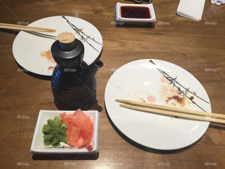 Empty plates at sushi with soy sauce, ginger and wasabi and of course chopsticks