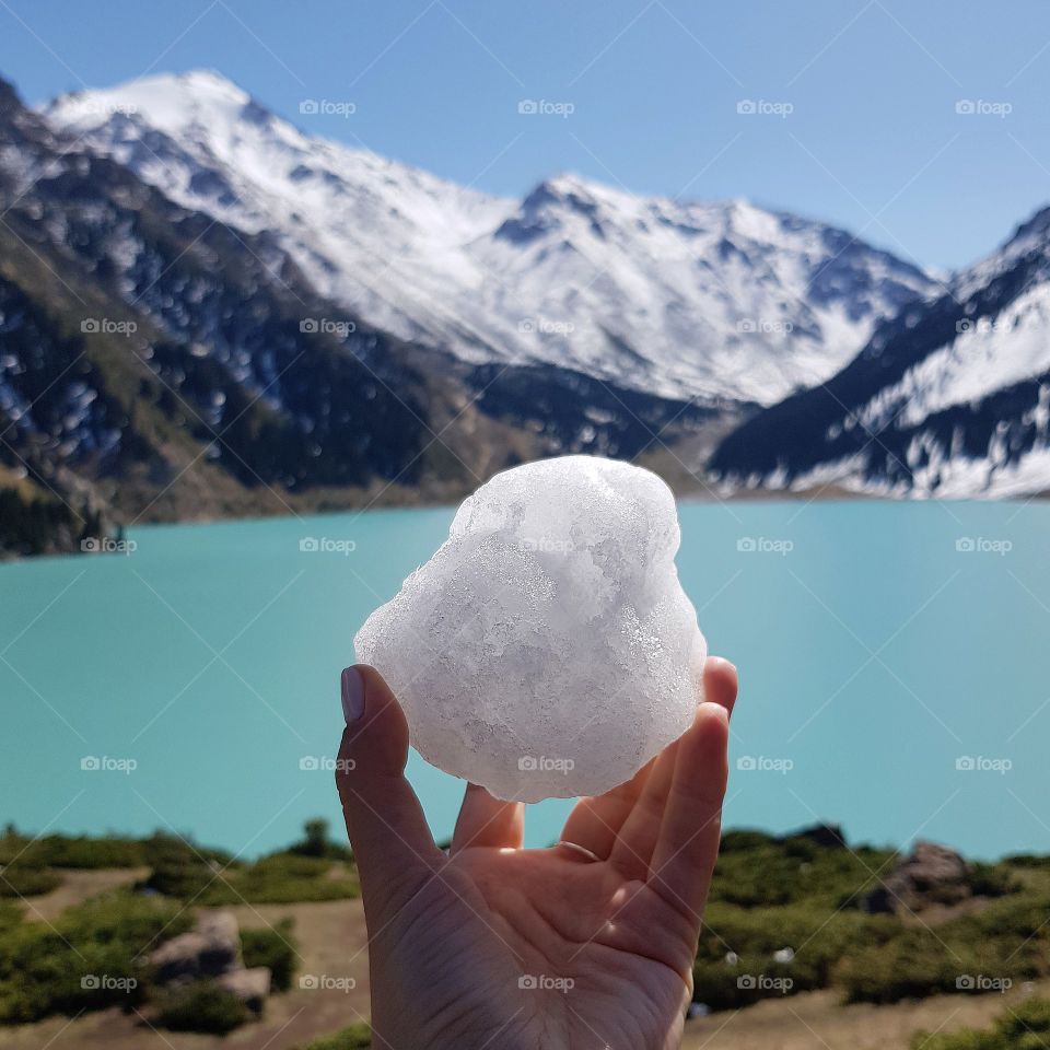 first snow in lady's hand at mountain lake in Kazakhstan