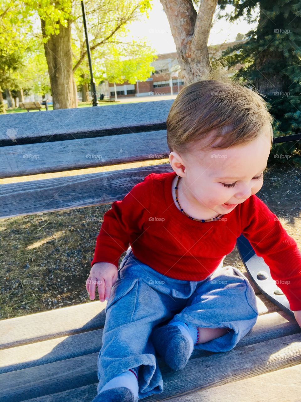 Baby boy on a park bench 